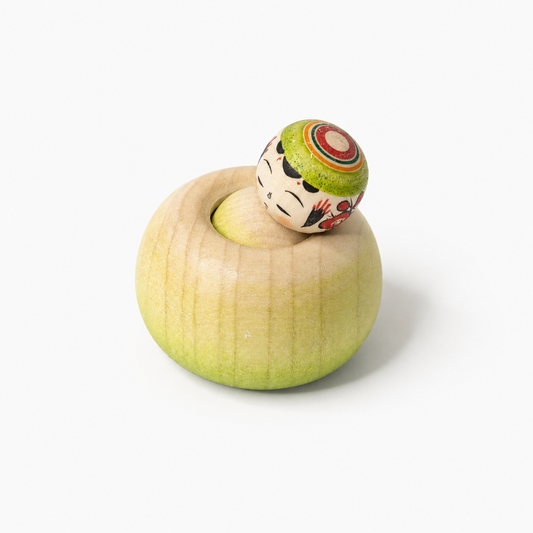 Matcha-grüne Ejiko-Kokeshi in Seitenansicht mit schlafendem Gesicht