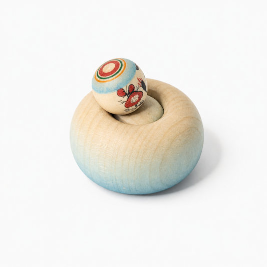 Blaue Ejiko-Kokeshi in Seitenansicht mit rotem Blütenmotiv am Kopf