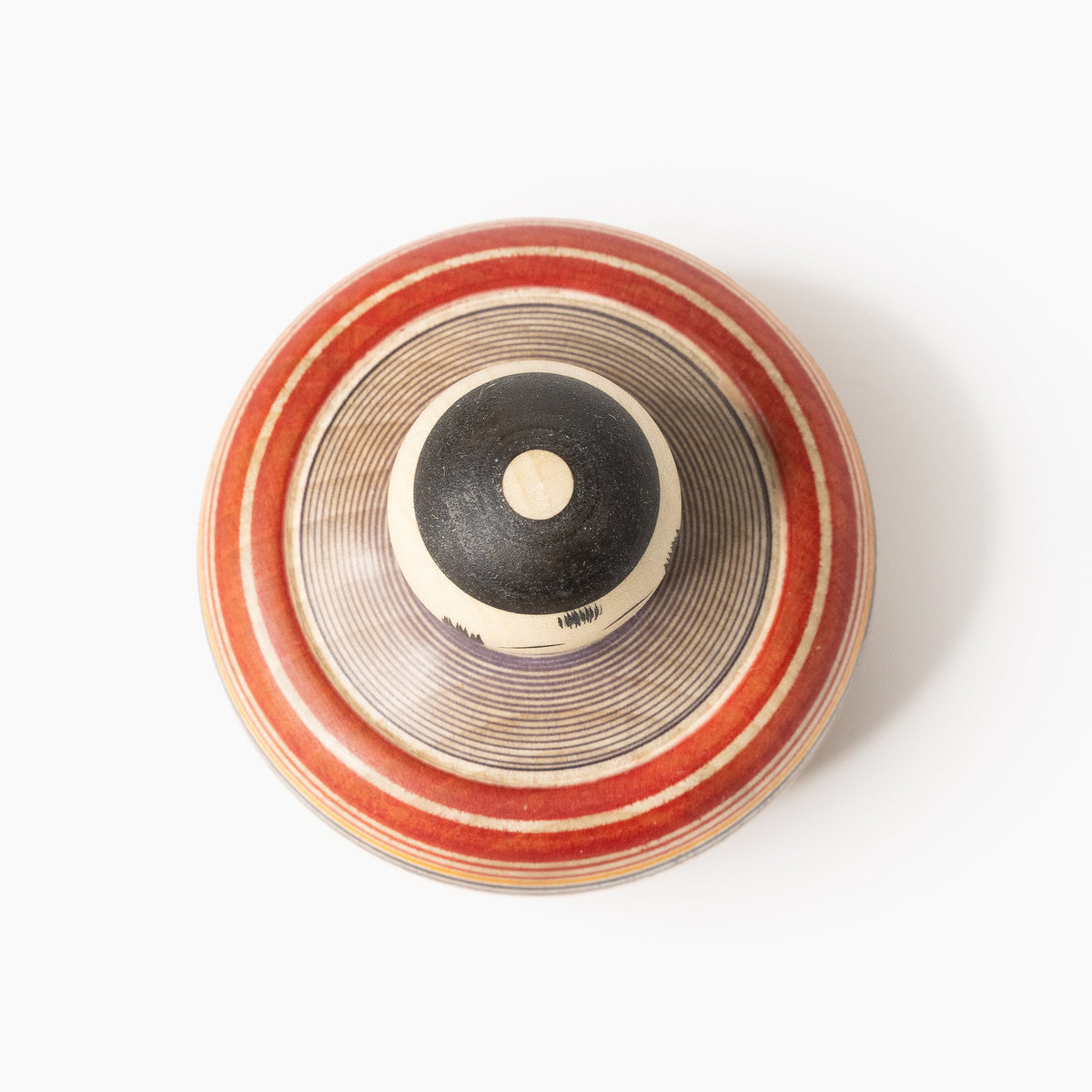 Top view of the Makoto-style Ejiko kokeshi in red and indigo