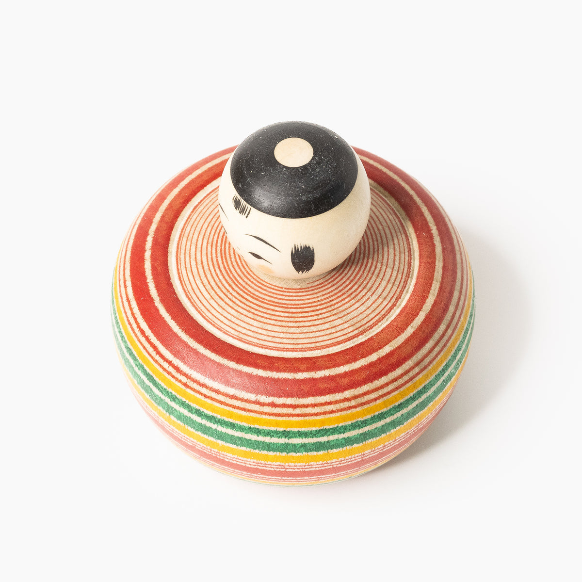 Top view of the Ejiko kokeshi with red and green lathe-painted rings