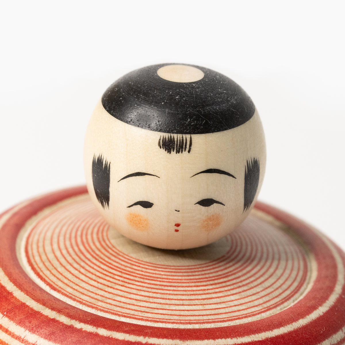 Facial detail of the Makoto-style Ejiko kokeshi in red and green