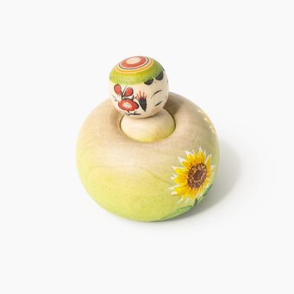 Ejiko-Kokeshi in Seitenansicht mit Sonnenblume und Blütenmotiv am Kopf