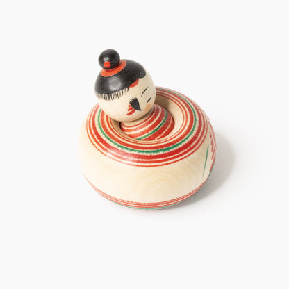 Mini-Ejiko-Kokeshi mit rot-grünem Ringmuster in schräger Vorderansicht