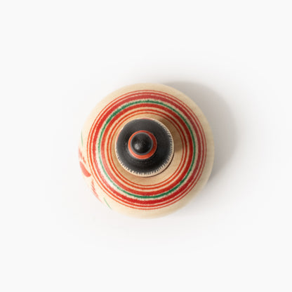Mini-Ejiko-Kokeshi von oben mit rot-grünen Drechselringen