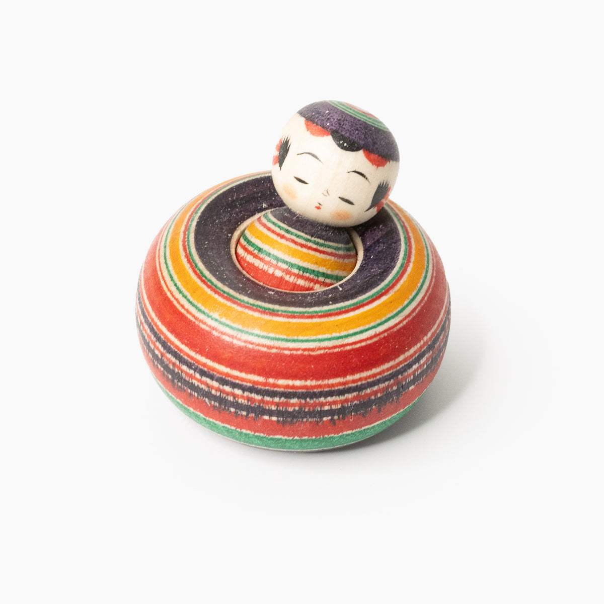 Ejiko-Kokeshi mit rot-schwarzem Makoto-Muster in schräger Vorderansicht